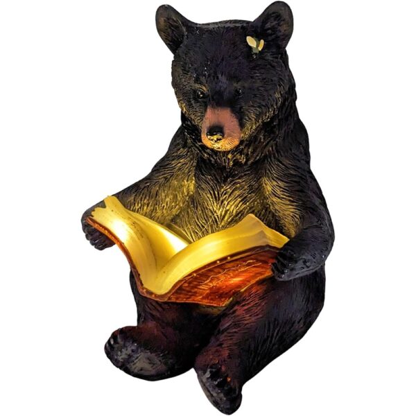 Charming solar-powered black bear reading a glowing book garden light.