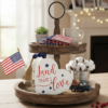 Decorative white heart plaque with a tassel and patriotic message.