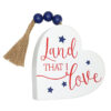 Decorative white heart plaque with a tassel and patriotic message.
