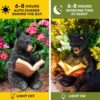 Charming solar-powered black bear reading a glowing book garden light.